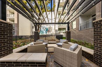 An outdoor patio with chairs and tables and a glass ceiling